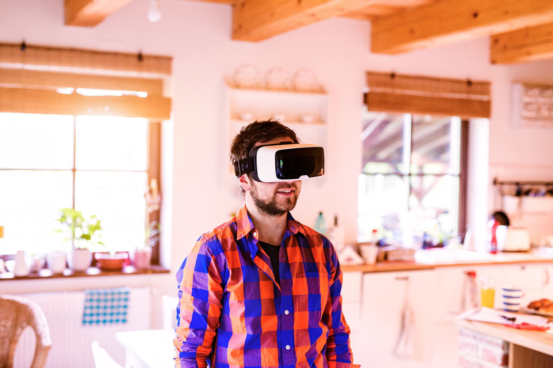 Man standing in living room with virtual reality headset on
