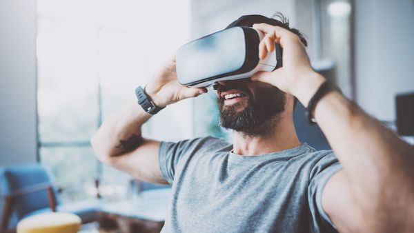 bearded man wearing and playing a virtual reality headset